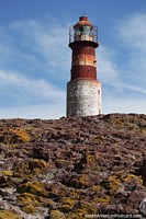 Lighthouse at the top of Penguin Island, rough rocky terrain, Puerto Deseado. Argentina, South America.