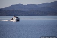 Coastguard boat speeds along the lake in Bariloche. Argentina, South America.