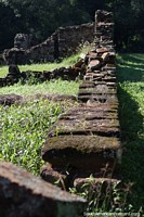 An unrestored part of the Jesuit ruins in San Ignacio with an area of old collapsed stone walls.
