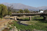 Ponte sobre o rio Xibi, gramado e pedregoso, com montanhas atrás em Jujuy. Argentina, América do Sul.