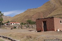 Terreno montanhoso e uma casa de tijolos de barro ao redor da Cuesta del Obispo, Rota 33.