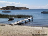 Beach, jetty, reeds, cow, boats, island at the Island Of the Sun, Lake Titicaca.