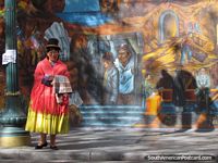 Hat lady in red and yellow and wall mural in La Paz.