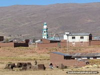 Larger version of Green church tower and locals working in a small community between La Paz and Desaguadero.