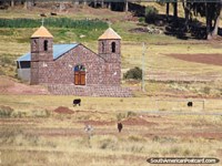 An old brick church with wooden door and 2 towers between Guaqui and Desaguadero.  Bolivia, South America.