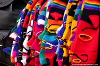 A row of full head balaclavas in a rainbow of colors in La Paz. Bolivia, South America.
