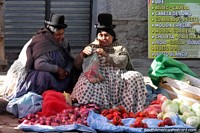 A woman bags some red peppers and also has onions and cabbages to sell, Mercado Rodriguez in La Paz. Bolivia, South America.