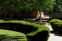 The fountain, hedges and trees in the gardens at Kohlberg Vineyard in Tarija. Bolivia, South America.