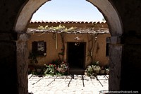 A visão por uma pedra arqueou a porta ao pátio no Velho Vinhedo de Casa perto de Tarija. Bolívia, América do Sul.