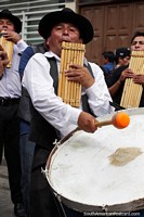 Man blows windpipes and plays bass drum at the same time at the carnival in Sucre.