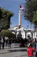 Obelisco with flag, tall monument in the plaza in the center of Potosi. Bolivia, South America.