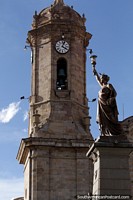 The liberty statue alongside the cathedral tower in Potosi, view from the plaza. Bolivia, South America.