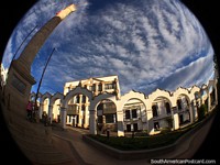 Iconic white arches and tall monument in Plaza 6th of August in Potosi. Bolivia, South America.