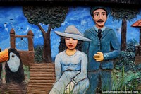 Hombre y mujer en el parque con una guacamaya, escultura de hormigón en la plaza de Riberalta. Bolivia, Sudamerica.