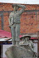 2 men rowing a boat, another man stands on the bow, one of several monuments in Riberalta. Bolivia, South America.