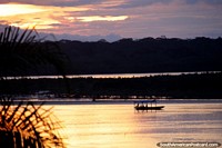 Bolivia Photo - Boat travels along the river in Riberalta at sunset.