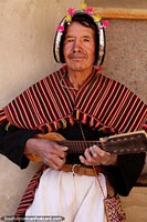 Playing a stringed instrument with 10 strings, an indigenous local man of Puka-Puka. Bolivia, South America.