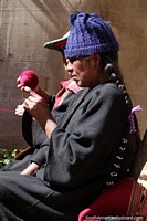La mujer teje con lana azul, tal vez sea otro sombrero azul, Puka-Puka. Bolivia, Sudamerica.
