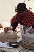 Moler el trigo en polvo con una piedra para tornear, formas tradicionales de los habitantes de Puka-Puka. Bolivia, Sudamerica.