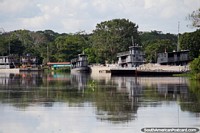 Large house boats and tug boats moored at a port on the Mamore River in Trinidad.