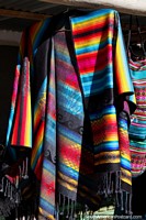 Roupa tradicional com um arco-ïris de cores brilhantes, para venda em Colchani, uma aldeia em Uyuni. Bolívia, América do Sul.