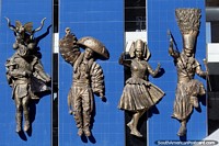 4 figures in traditional costumes and masks, amazing bronze work on a building side in Oruro, carnival. Bolivia, South America.