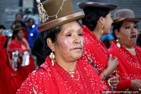 Vestida de rojo con grandes aretes, una mujer con sombrero boliviano en el desfile de El Gran Poder en La Paz. Bolivia, Sudamerica.