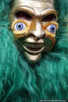 A cheeky grin and wide eyes, a mask with long green hair, El Gran Poder parade, La Paz. Bolivia, South America.