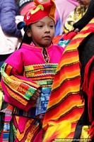 Child dressed in an amazing pink technicolor outfit marches in the El Gran Poder parade in La Paz.