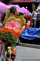 Plume of purple smoke explodes from the canister and an outrageous costume at the El Gran Poder festival, La Paz. Bolivia, South America.