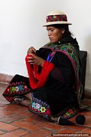 Mulher em roupa tradicional que se une com lã vermelha no museu de artes têxtil (Cetur) em Sucre. Bolívia, América do Sul.
