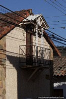 Casa con puerta a un pequeo balcn techado en Samaipata.