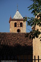 Church tower behind a tiled roof in San Jose de Chiquitos.
