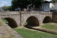 Rosario Bridge, an old stone bridge with 3 arches and a cross in Sao Joao del Rei.