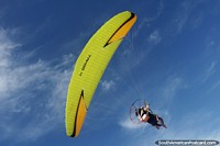 2 people fly over on a powered paraglider in Canoa Quebrada.