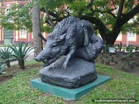 Wild dog attacks wild boar statue in Manaus park.