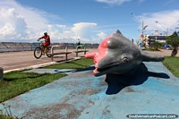 Rosa y gris monumento de un delfine en la zona ribereña en Santarem. Brasil, Sudamerica.