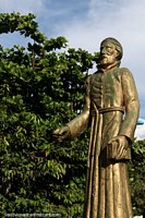 Versión más grande de Una segunda estatua de oro de un hombre que sostiene un libro en una plaza en el centro de Santarem.