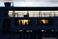 Puesta del sol a través de las ventanas de un ferry con el lado hamacas al lado del otro, de Santarem. Brasil, Sudamerica.