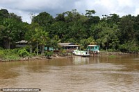 Casas ao longo do Rio Parauau, um barco entrou em doca na frente, ao norte de Breves. Brasil, América do Sul.