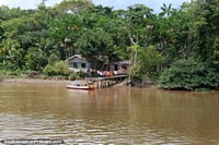 Boat arrives to pick up a man from his house in the Amazon jungle north of Breves. Brazil, South America.