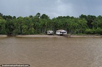 A pair of houses on a private beach location in the Amazon along the Parauau River, north of Breves. Brazil, South America.