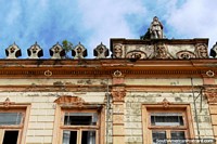 Old and interesting facade with a small statue at the top in Belem. Brazil, South America.