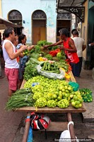 Lots of green vegetables for sale from this mans table at Ver-o-Peso Market in Belem. Brazil, South America.