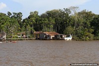 Uma orla comunidade de Amazônia, que se lava na linha, navega em canoa passos, ao oeste de Belém. Brasil, América do Sul.