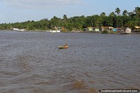 Uma mulher em uma canoa no rio em frente da sua comunidade no Amazônia, ao oeste de Belém. Brasil, América do Sul.