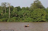 Woman and child in a canoe on a river south of Macapa. Brazil, South America.