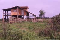 Edifïcio de tijolos em pernas de pau de madeira em terra áspera entre Macapa e Oiapoque. Brasil, América do Sul.