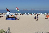 People enjoying Ipanema Beach in Rio de Janeiro, white sands and small islands. Brazil, South America.