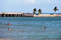 People swimming at the less crowded end of Pajucara Beach in Maceio. Brazil, South America.